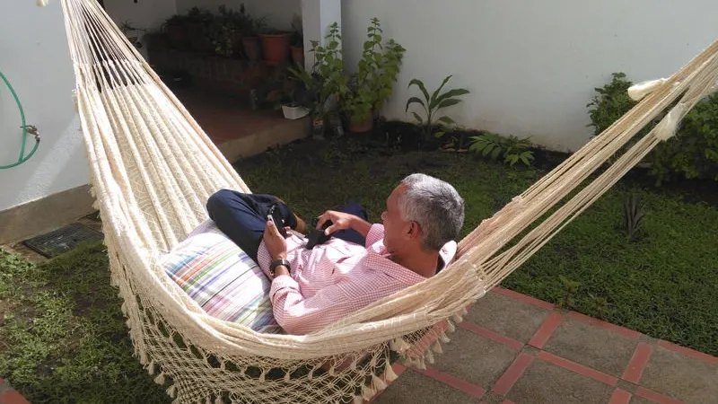 Persona descansando en un chinchorro de curagua en un jardín