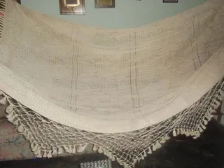 Chinchorro de curagua con su trama tejida a mano y randas de macramé